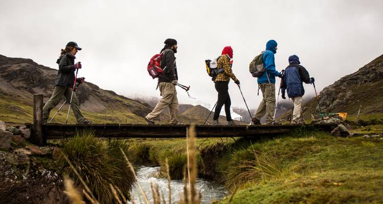 Menschen die een brug oversteken in een bergachtig landschap.