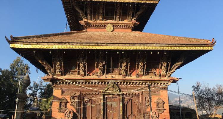 Helder zicht op een historische tempel met bergen op de achtergrond.