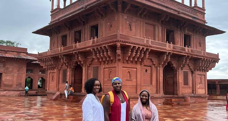 Trois personnes posant devant un fort indien historique