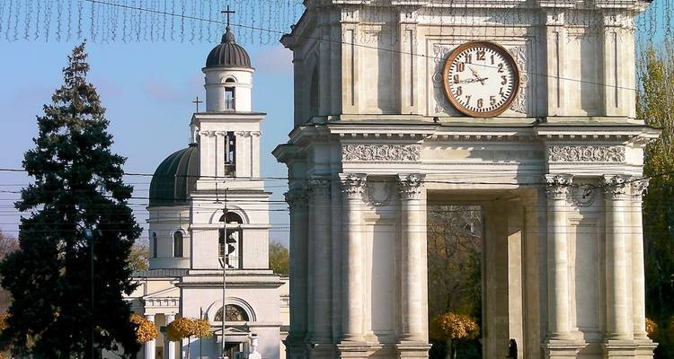 Bogen mit einer Uhr und einem Glockenturm auf einem Stadtplatz.