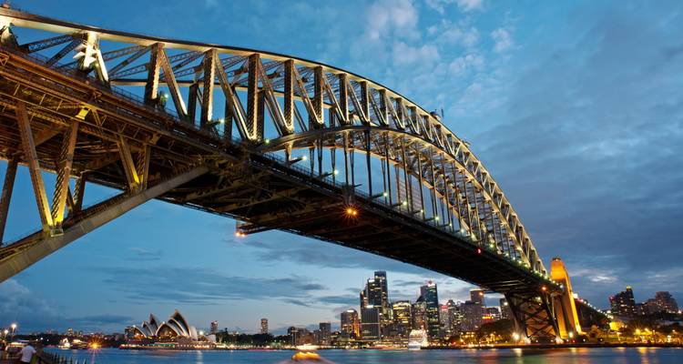 Sydney Harbour Bridge bij zonsondergang met stadsgezicht.