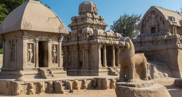 Ancient stone structures with carvings set against a clear sky.