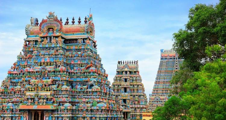 Intricately carved colorful temple towers under a blue sky.