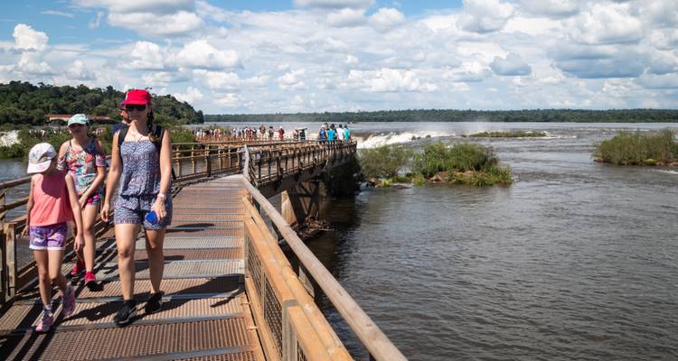 People walking on a bridge with a river view.