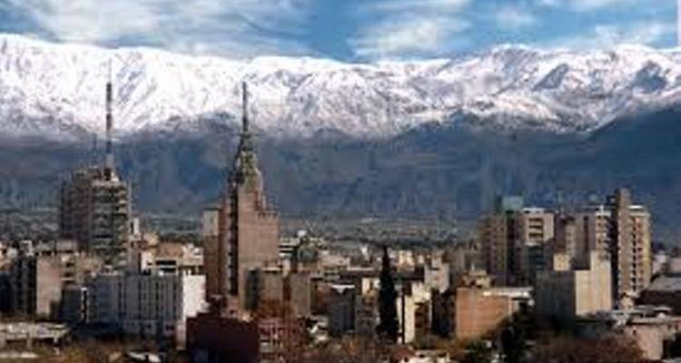 Cityscape with tall buildings and mountains.