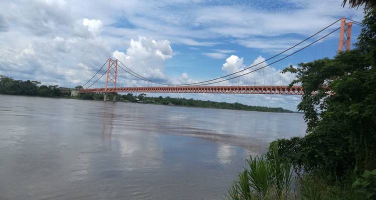 Eine lange Brücke, die einen breiten Fluss unter einem blauen Himmel überquert.