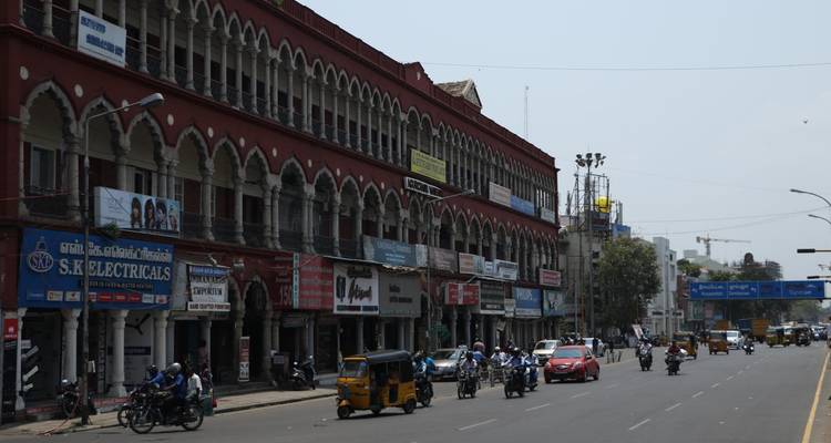 A busy street scene in a city with shops and traffic.