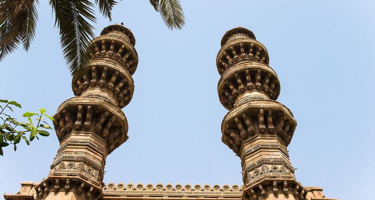 Two ornate minarets rising against the sky with architectural detailing.