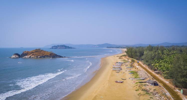 Küstenlandschaft mit einem langen Sandstrand und kleinen Booten