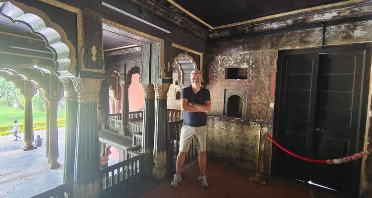 Mann posiert in einem antiken Gebäude mit Holzausstattung.