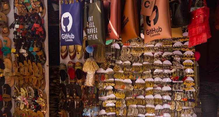 Market stall displaying bags and accessories.