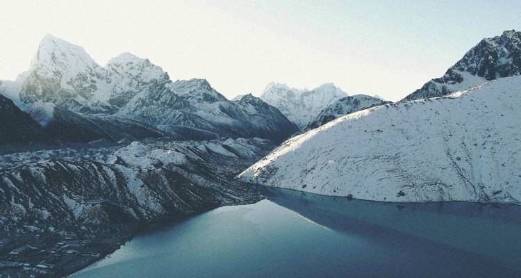 Sneeuwbedekt berglandschap met meer.