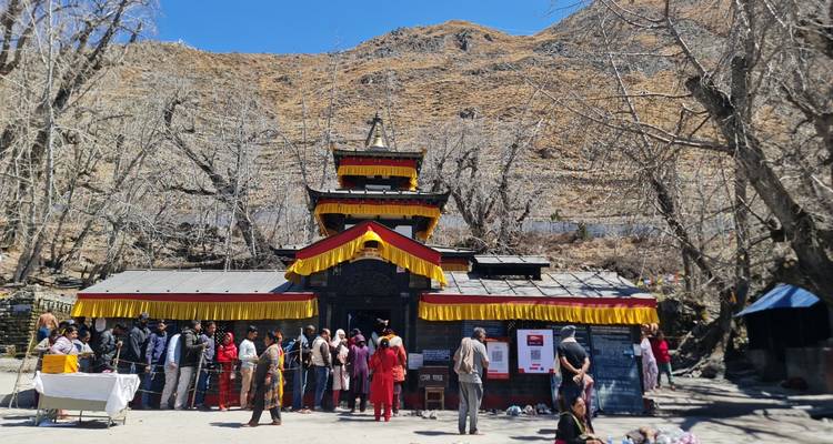 Pilger warten vor dem farbenfrohen Muktinath-Tempel Schlange, der sich gegen die kargen Hänge des Himalajas abhebt.