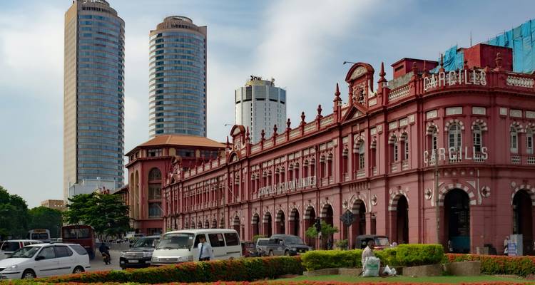 Edificio colonial rosa histórico y rascacielos modernos alineados en una calle concurrida de una ciudad costera urbana