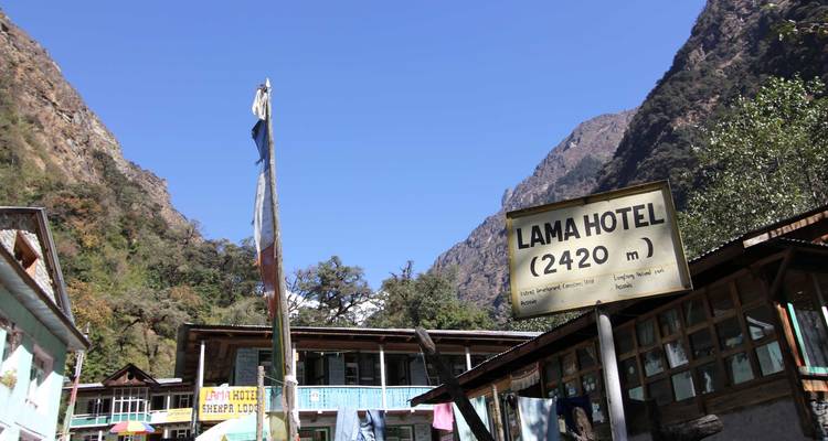 Panneau de l'hôtel Lama indiquant l'altitude au milieu des collines.
