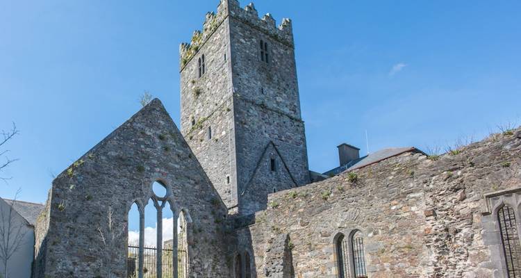 Tour de pierre et ruines sous un ciel bleu clair.