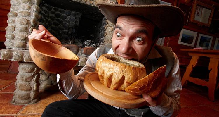 Person, die eine traditionelle Mahlzeit mit Brotschüssel genießt.