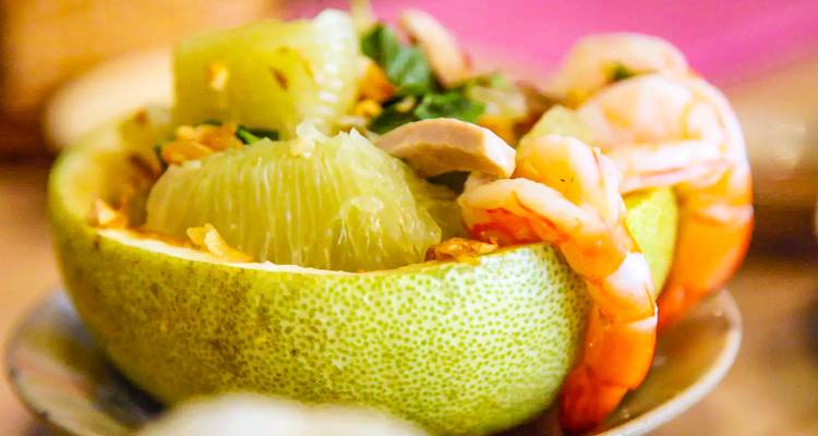 Een gerecht met garnalen en pomelo geserveerd in een pomeloschill.