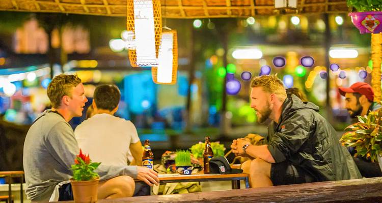 Groep mensen die geniet van drankjes en gesprek in een gezellige omgeving.