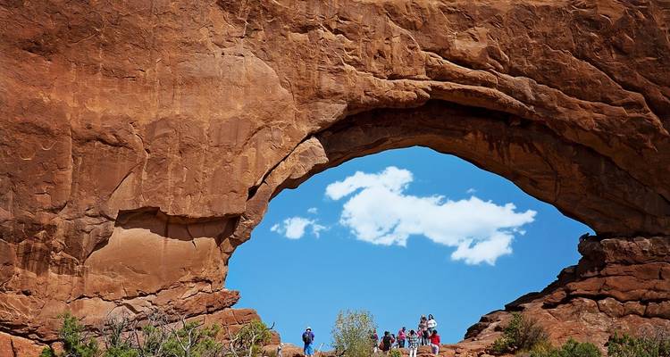 Groep mensen onder een grote rotsboog.