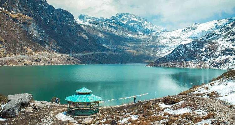 Türkiser See umgeben von schneebedeckten Bergen.