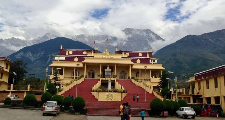 Majestätisches Gebäude mit rot-goldenem Motiv vor Bergkulisse.