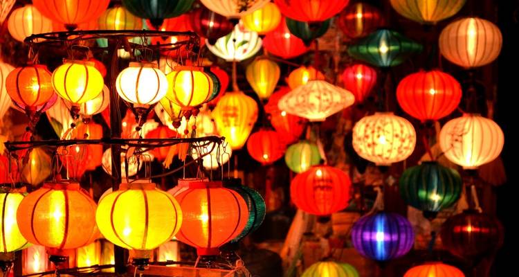 Close-up of colorful traditional lanterns glowing warmly in the night.