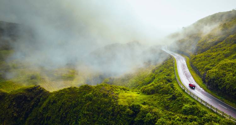 Schilderachtige weg die kronkelt door met mist bedekte heuvels.
