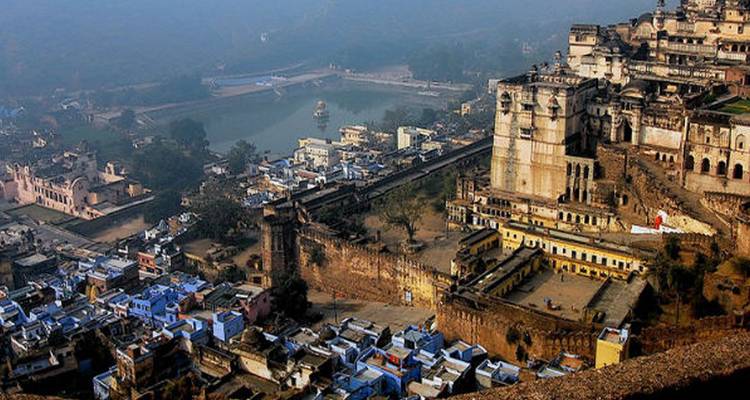 Historische Stadtansicht mit einer Festung und umliegenden Gebäuden.