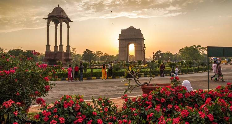 India Gate mit leuchtenden Blumen bei Sonnenuntergang.