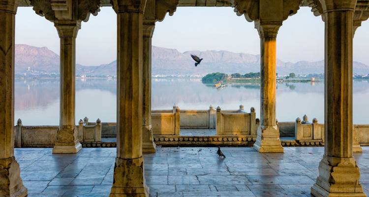 Blick auf den See und die Berge durch einen kunstvollen Pavillon.