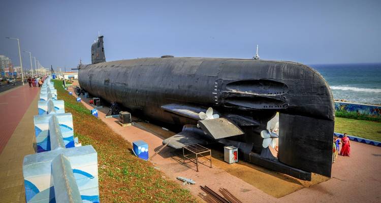 U-Boot im Freien in der Nähe eines Strandes ausgestellt, mit Menschen, die es betrachten.