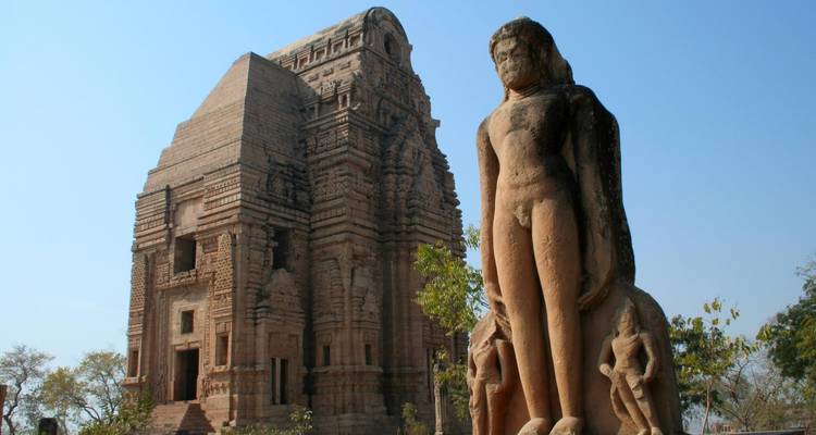 Tempel met groot Jain-standbeeld op de voorgrond.