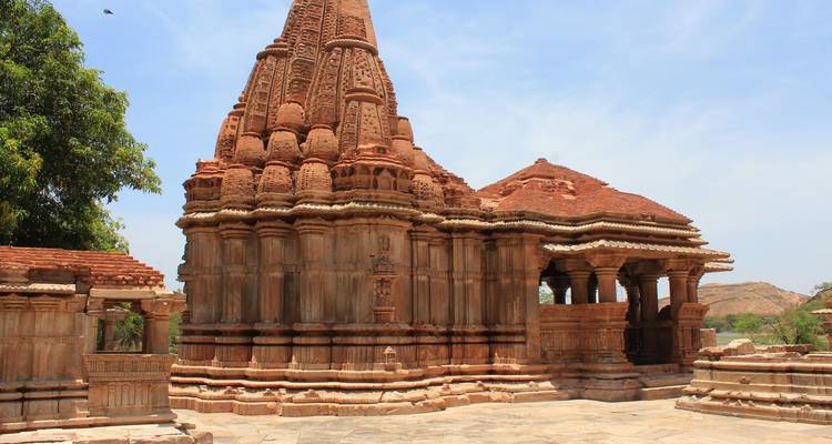 Ein alter Steintempel mit kunstvollen Schnitzereien und klarem blauem Himmel.