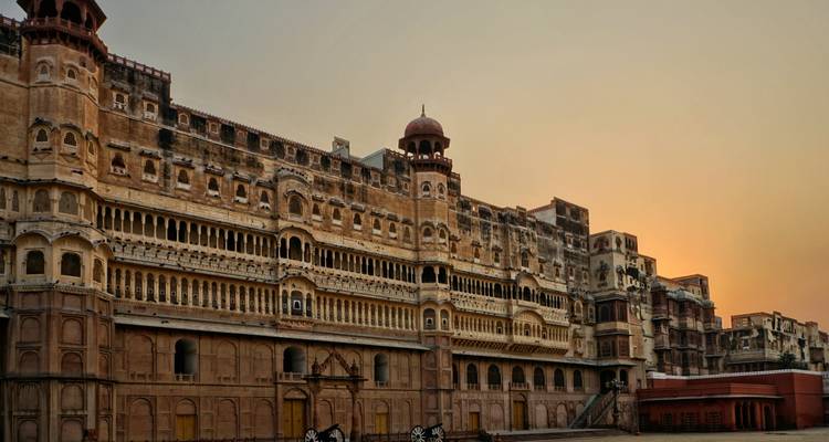 Eine große historische Festung bei Sonnenuntergang mit kunstvoller Architektur.