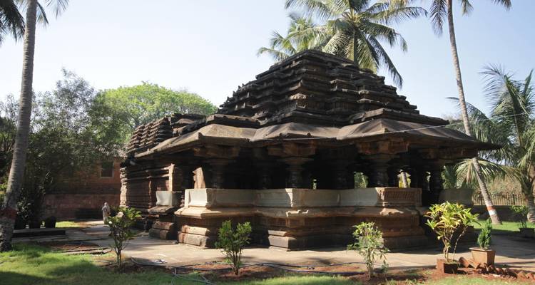 Antiker Tempel mit Steinsäulen und Touristen, die Fotos machen.