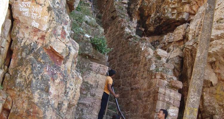 Menschen, die eine felsige Treppe mit Graffiti auf den Steinen hinaufsteigen.