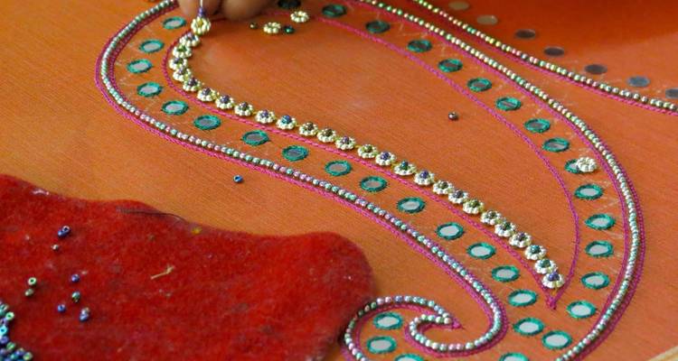 Close-up van ingewikkeld borduurwerk met een werkende hand