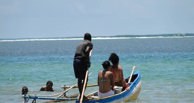 People on a small boat in clear ocean water.