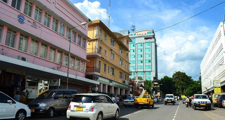 Busy street with colorful buildings and parked cars.