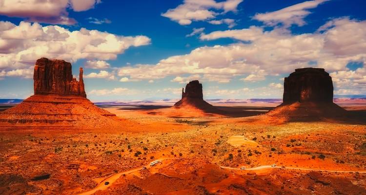 Ikonische Felsformationen, die aus einer Wüstenlandschaft unter blauem Himmel emporragen.