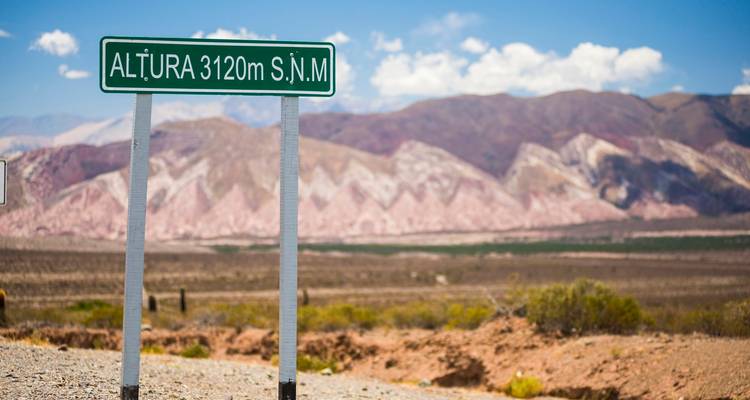 Een verkeersbord dat de hoogte aangeeft met een schilderachtig uitzicht op bergen.