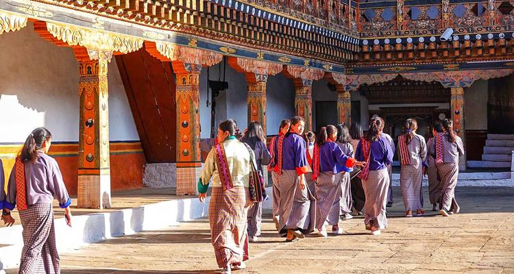 Eine Gruppe von Menschen in traditioneller Kleidung, die in einem Innenhof gehen.