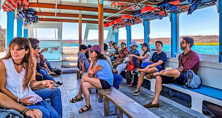 Gruppe von Menschen auf einem Boot mit einer malerischen Aussicht auf Wasser und Landschaft.