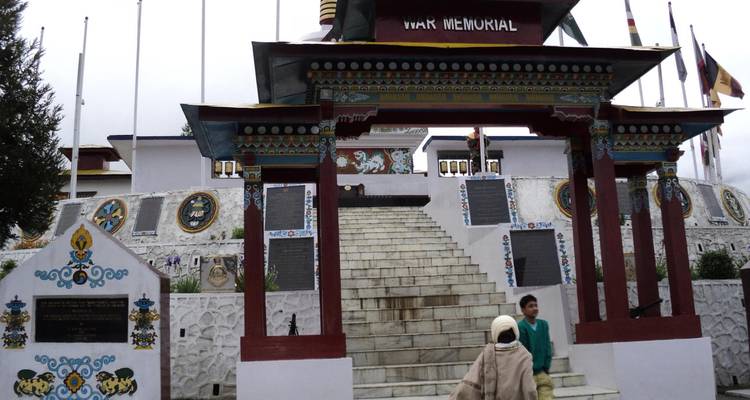 Oorlogsmonument ingang met decoratieve elementen en mensen.