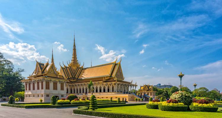 Les bâtiments ornés du Palais Royal en or se dressent au-dessus de jardins impeccablement entretenus sous un ciel bleu éclatant de Phnom Penh.