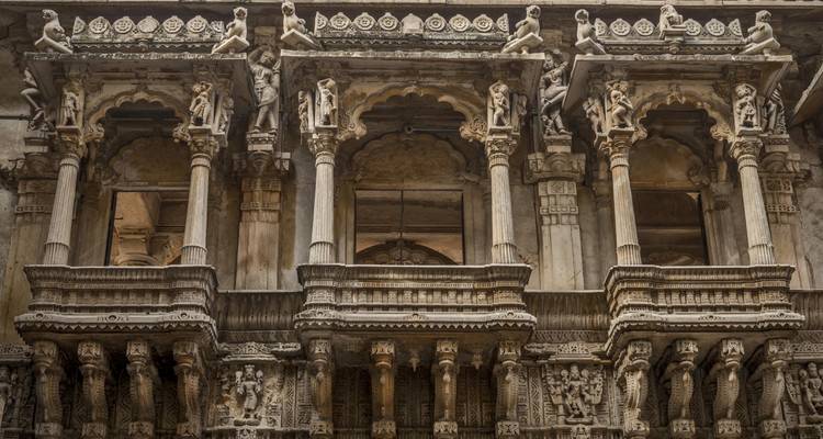 Detaillierte Fassade eines historischen Gebäudes mit kunstvoll geschnitzten Balkonen.