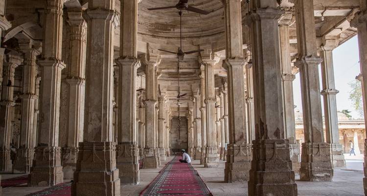Interior perspective of a mosque with rugs and columns.