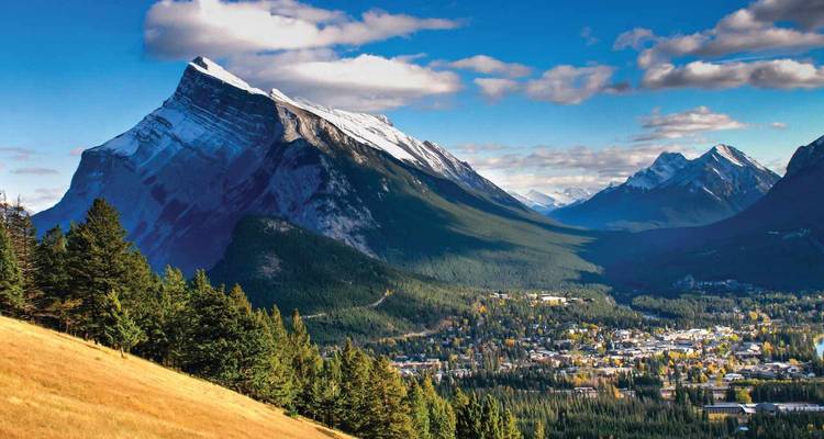 View over Banff town nestled in a valley with snow-capped Mount Rundle towering above