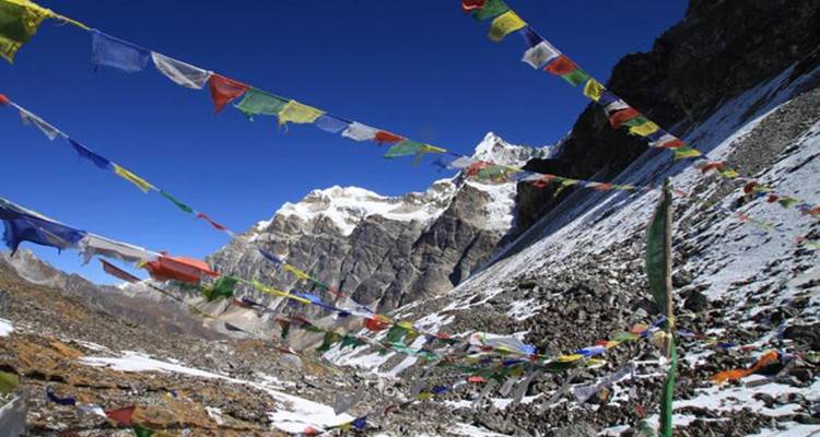 Gebedsvlaggen met een besneeuwde berg op de achtergrond.